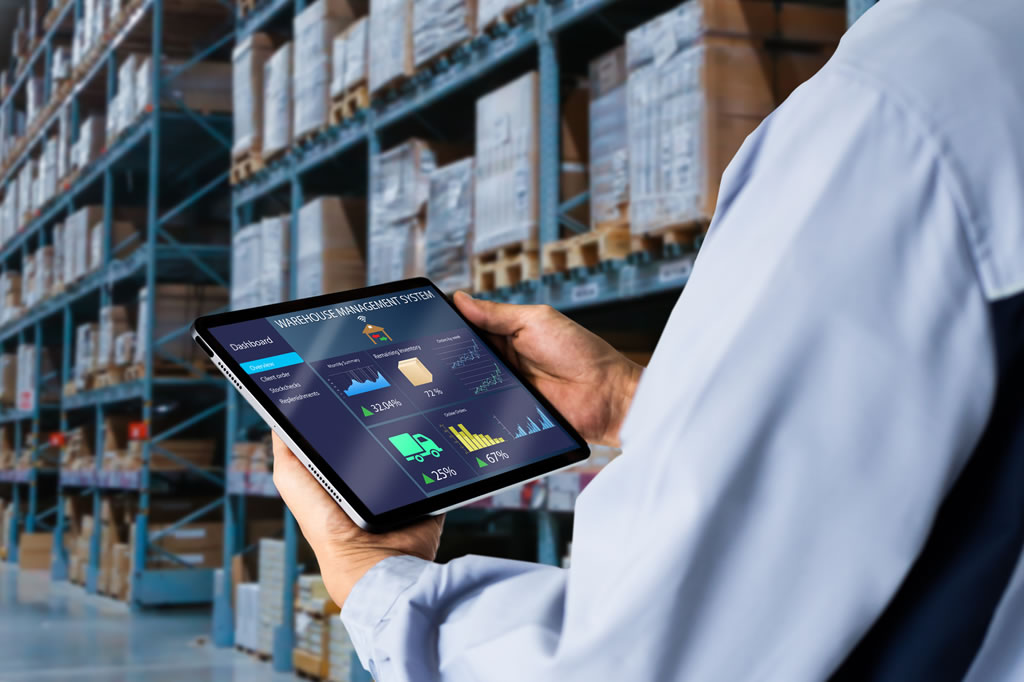 Logistics manager in a wharehouse using a tablet.