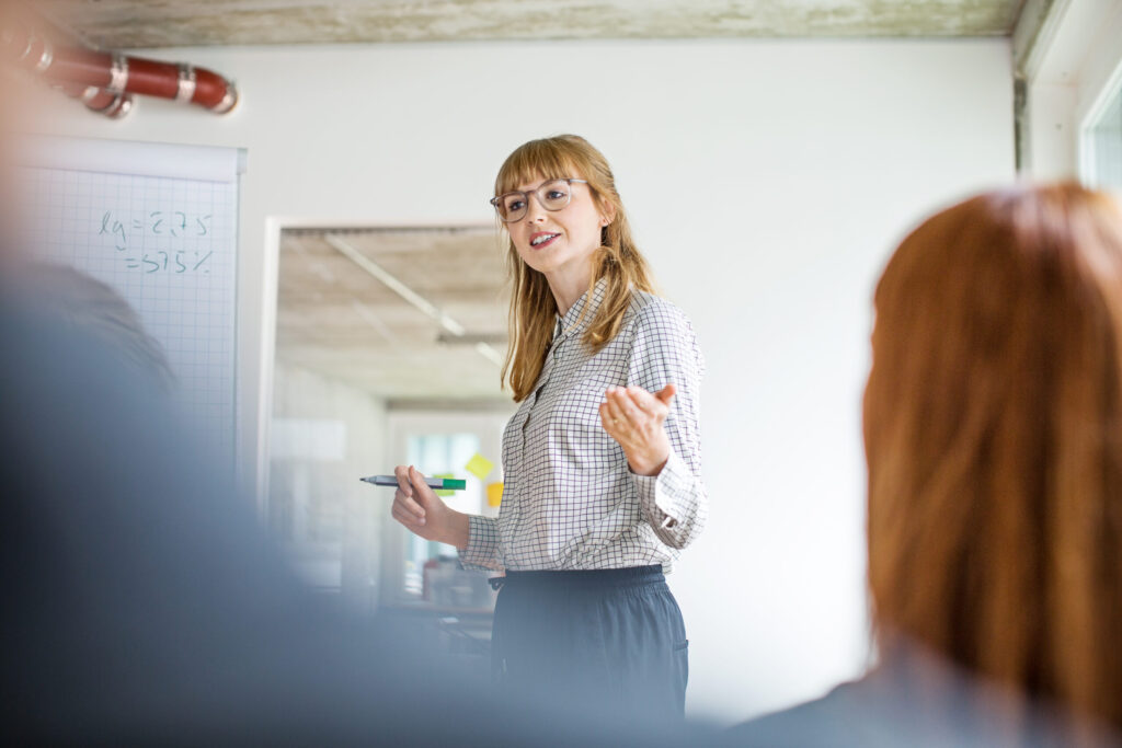 A budget analyst presents data to a group in an office.