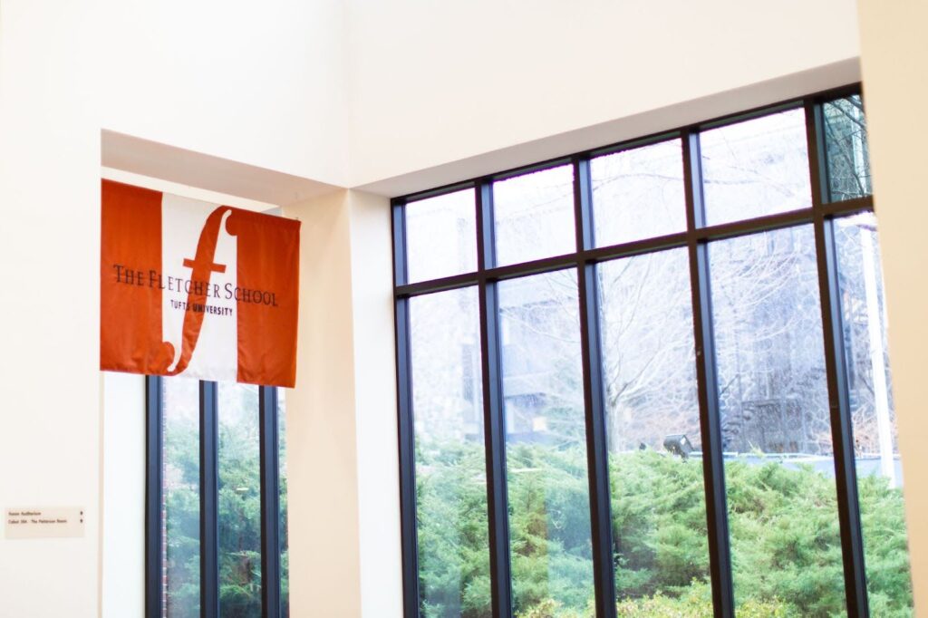 The Fletcher School banner displayed in the window of a Tufts academic building.